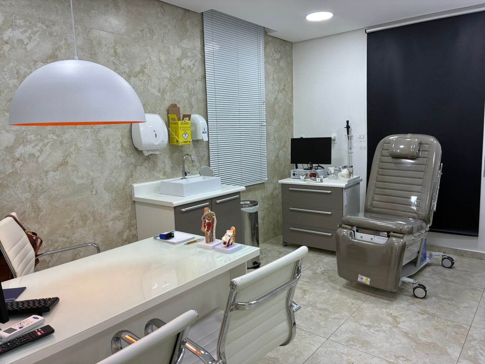 Sala de exames equipada com cadeira otorrinolaringológica e equipamentos modernos